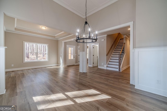 unfurnished dining area featuring a notable chandelier, dark hardwood / wood-style floors, and ornamental molding