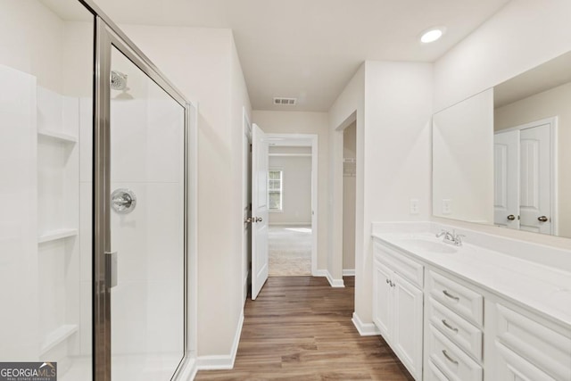 bathroom featuring a shower with door, vanity, and wood-type flooring