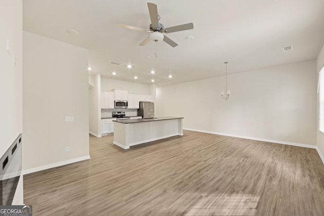 unfurnished living room with light hardwood / wood-style flooring and ceiling fan with notable chandelier