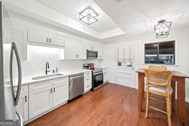 kitchen featuring sink, stainless steel appliances, an inviting chandelier, dark hardwood / wood-style floors, and white cabinets