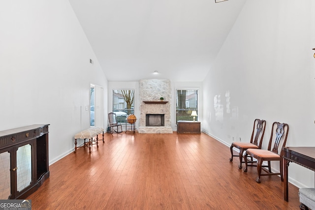 living room featuring a fireplace, hardwood / wood-style flooring, and high vaulted ceiling