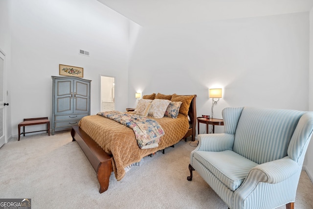 carpeted bedroom with a high ceiling