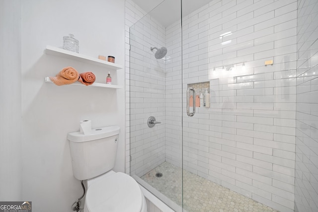 bathroom with toilet and a shower with door