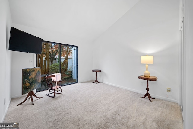 sitting room with light colored carpet and high vaulted ceiling