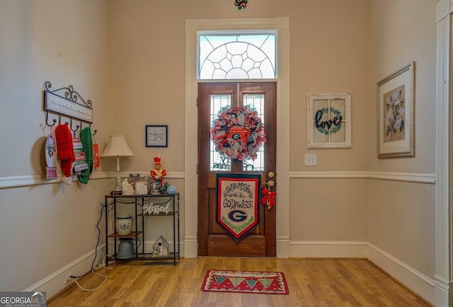 foyer featuring baseboards and wood finished floors