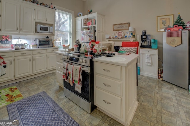 kitchen featuring electric range, a center island, and white cabinetry