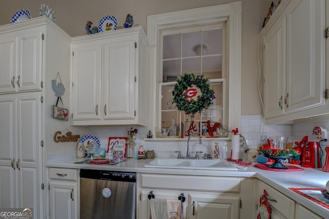 kitchen with light countertops, dishwasher, a sink, and white cabinetry