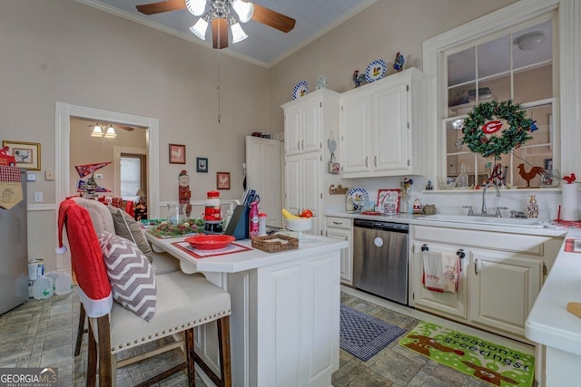 kitchen with ceiling fan, a kitchen island, light countertops, crown molding, and stainless steel dishwasher