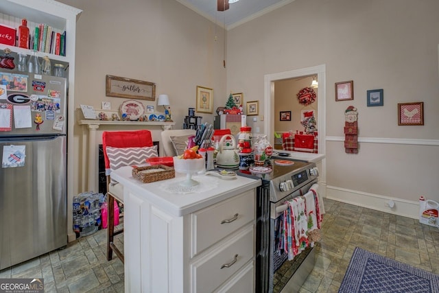 kitchen featuring stainless steel appliances, white cabinetry, baseboards, light countertops, and stone finish flooring