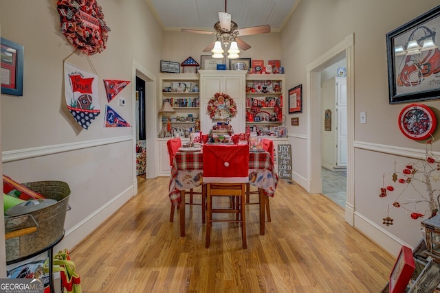 dining area with ceiling fan, light wood-type flooring, and ornamental molding