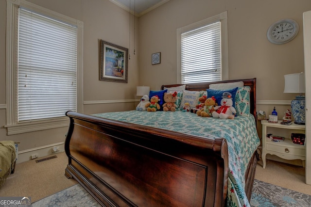 carpeted bedroom featuring ornamental molding and visible vents