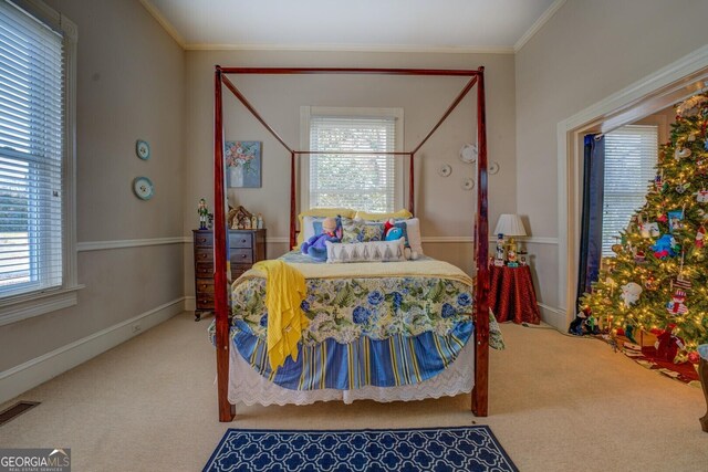 carpeted bedroom featuring multiple windows and ornamental molding