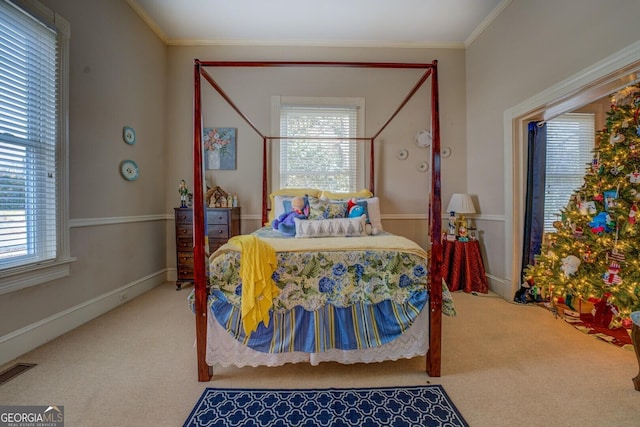 carpeted bedroom featuring baseboards, visible vents, and crown molding