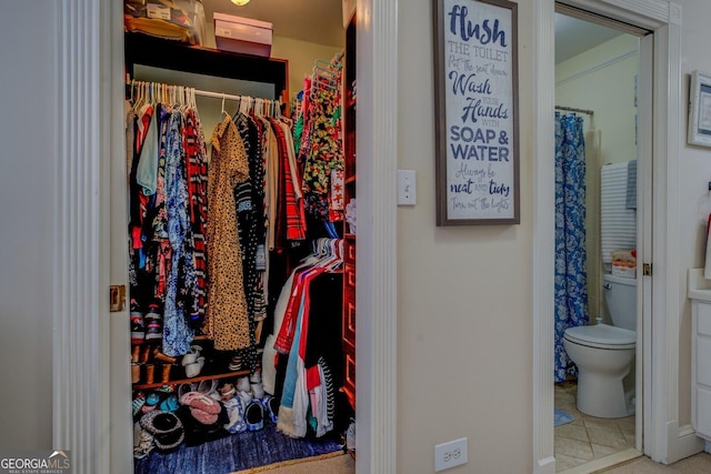 walk in closet with tile patterned floors