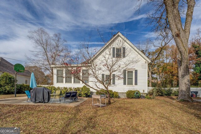 back of house featuring a lawn and a patio area