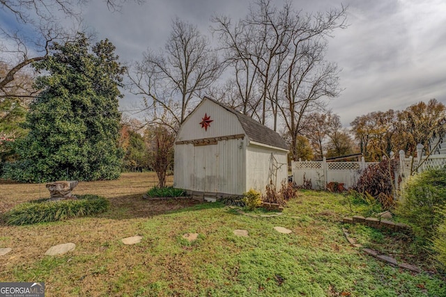 exterior space featuring a storage shed, an outdoor structure, and fence