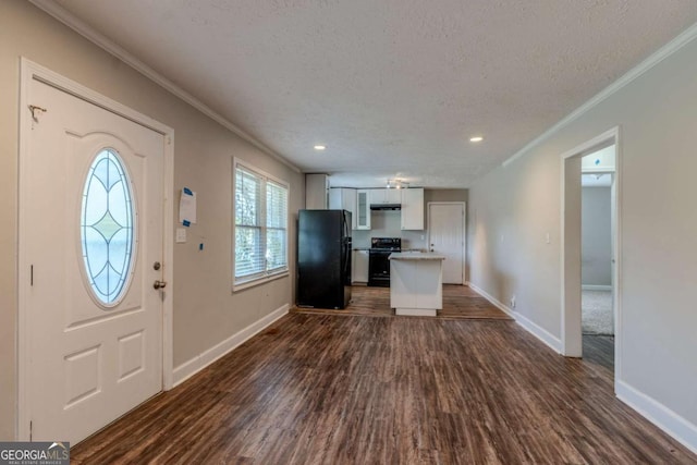 foyer entrance featuring a textured ceiling, crown molding, and dark wood-type flooring