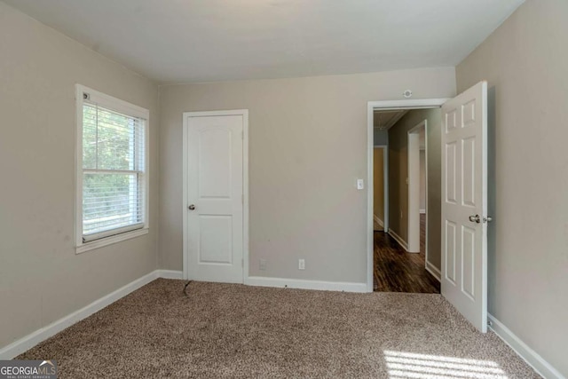 unfurnished bedroom with dark carpet