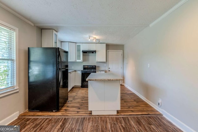 kitchen with a textured ceiling, dark hardwood / wood-style floors, white cabinetry, and black appliances