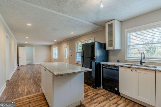 kitchen with sink, white cabinets, black appliances, and light wood-type flooring