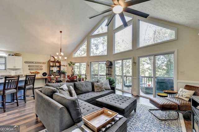 living room with high vaulted ceiling, a healthy amount of sunlight, and wood-type flooring