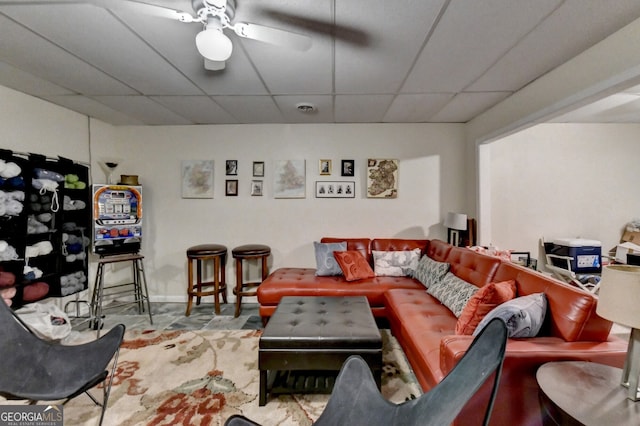 living room with ceiling fan and a drop ceiling