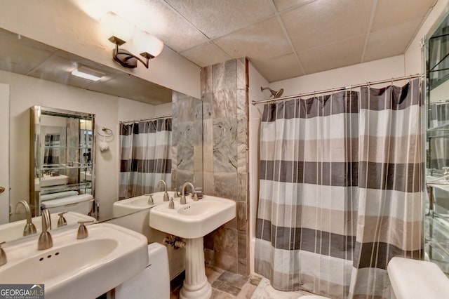 bathroom featuring a paneled ceiling, curtained shower, and tile walls