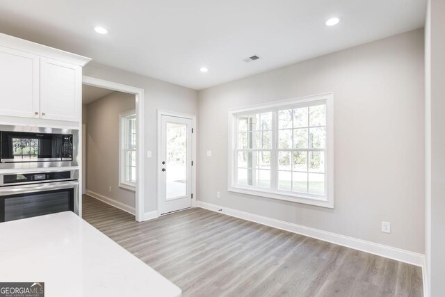 408 Bella Notte Cir Unit 26A, Warner Robins, GA 31088 - kitchen featuring appliances with stainless steel finishes, light wood-type flooring, white cabinets, recessed lighting, and light countertops