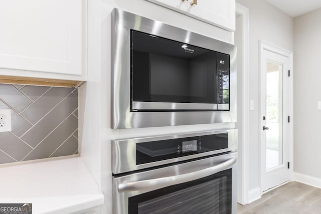 408 Bella Notte Cir Unit 26A, Warner Robins, GA 31088 - kitchen view of built in microwave, oven, white cabinets, and light wood-type flooring
