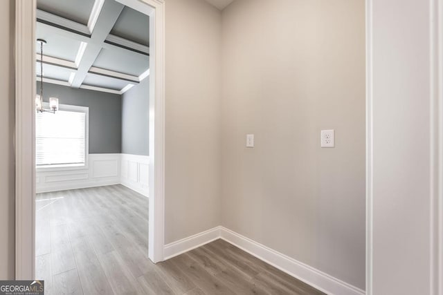 408 Bella Notte Cir Unit 26A, Warner Robins, GA 31088 - hallway with coffered ceiling, beam ceiling, wood finished floors, a wainscoted wall, and a chandelier