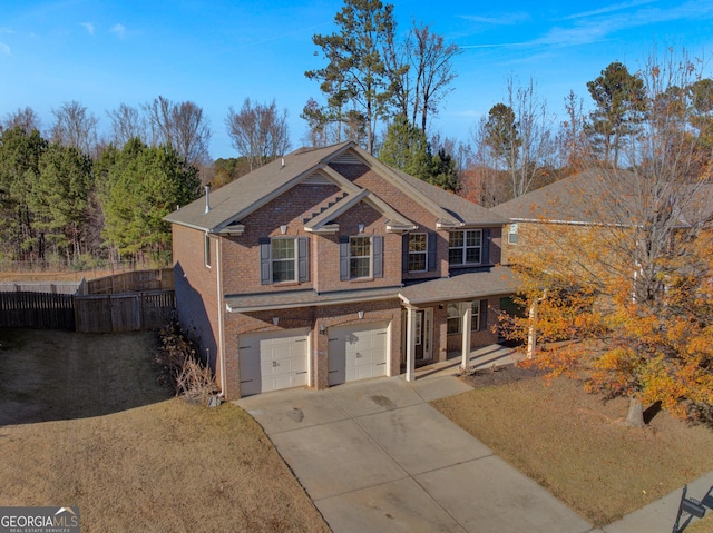 view of front of house featuring a garage, brick siding, fence, concrete driveway, and a front lawn