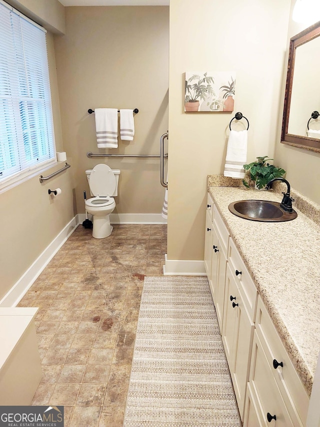 bathroom with vanity, toilet, and baseboards