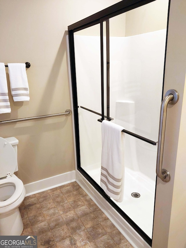 bathroom featuring an enclosed shower and toilet