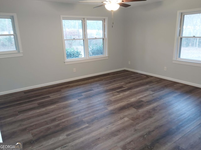 spare room with dark wood finished floors, ceiling fan, and baseboards