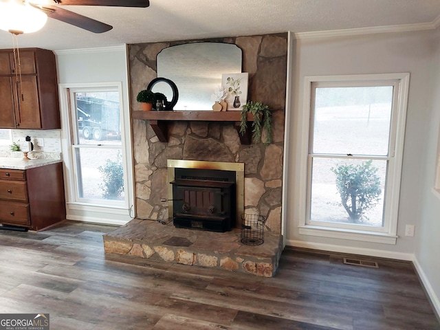 living area featuring wood finished floors, a ceiling fan, visible vents, and ornamental molding