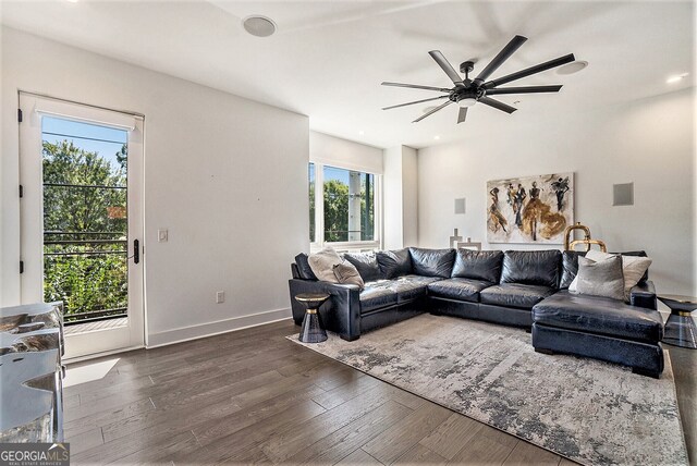 living room featuring ceiling fan and dark hardwood / wood-style flooring