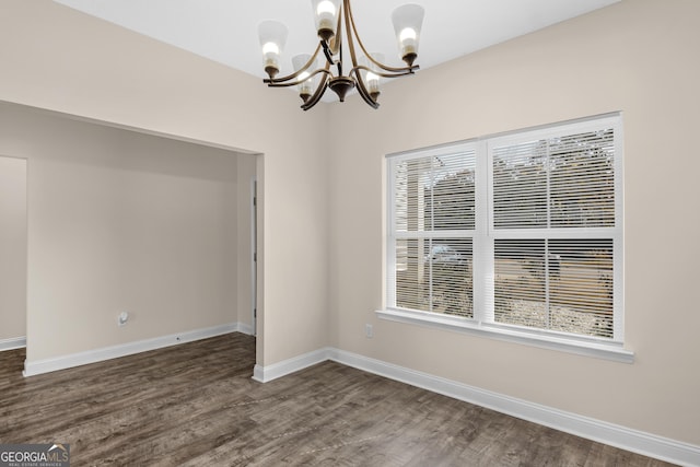 299 Archibald Ave SE, Ludowici, GA 31316 - unfurnished dining area featuring an inviting chandelier, baseboards, and dark wood-type flooring
