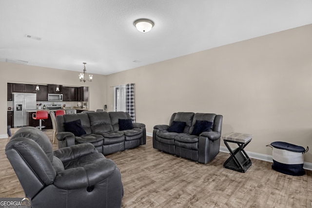 living room with light hardwood / wood-style flooring and a notable chandelier