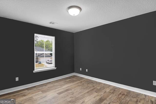 299 Archibald Ave SE, Ludowici, GA 31316 - spare room with a textured ceiling, visible vents, wood finished floors, and baseboards