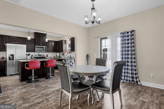 dining room with light hardwood / wood-style flooring and a notable chandelier