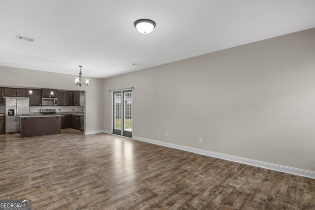 299 Archibald Ave SE, Ludowici, GA 31316 - unfurnished living room with an inviting chandelier, visible vents, dark wood-style flooring, and baseboards