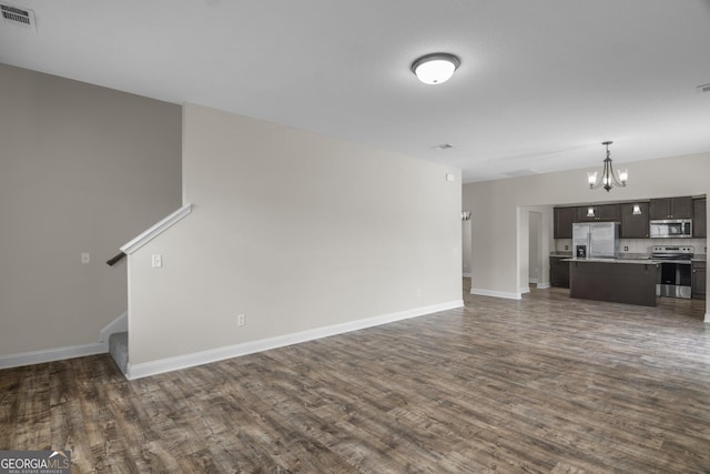 299 Archibald Ave SE, Ludowici, GA 31316 - unfurnished living room featuring baseboards, dark wood finished floors, an inviting chandelier, and visible vents