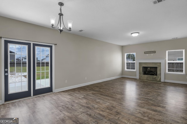 299 Archibald Ave SE, Ludowici, GA 31316 - unfurnished living room with visible vents, wood finished floors, baseboards, and a notable chandelier