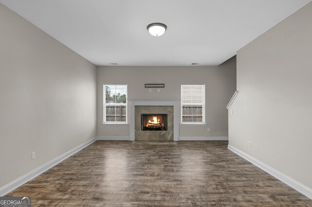 299 Archibald Ave SE, Ludowici, GA 31316 - unfurnished living room featuring baseboards, dark wood-style floors, and a tile fireplace