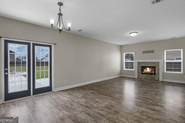 299 Archibald Ave SE, Ludowici, GA 31316 - unfurnished living room featuring an inviting chandelier, baseboards, visible vents, and wood finished floors