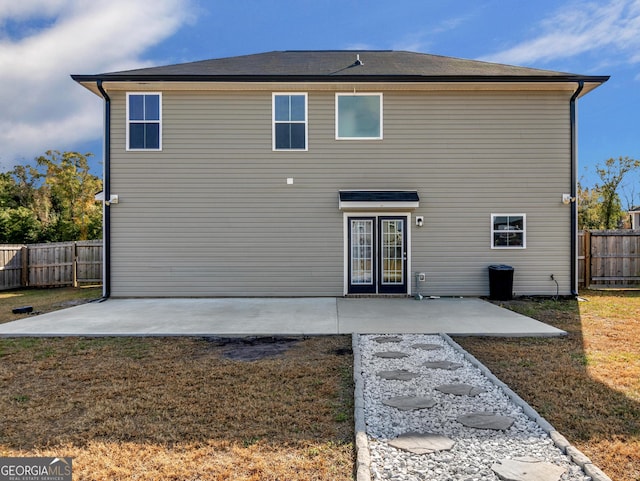 rear view of house with a lawn and a patio