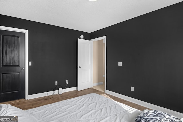 bedroom with a textured ceiling and light hardwood / wood-style floors