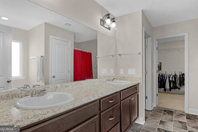 299 Archibald Ave SE, Ludowici, GA 31316 - full bath with double vanity, baseboards, a spacious closet, and a sink