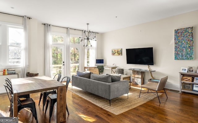 living room featuring dark hardwood / wood-style flooring and an inviting chandelier