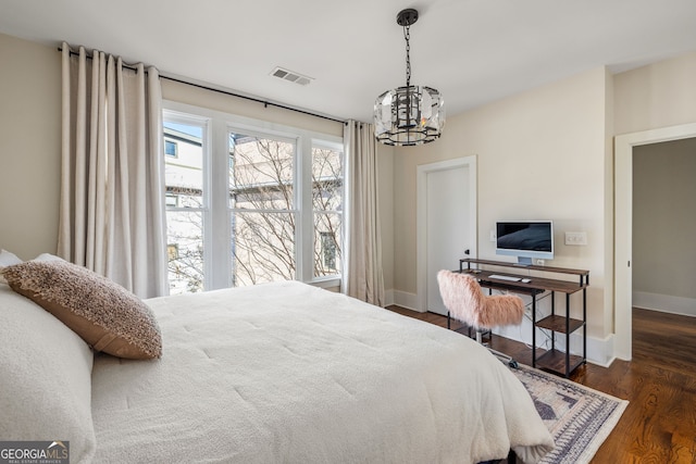 bedroom featuring dark hardwood / wood-style floors and a notable chandelier